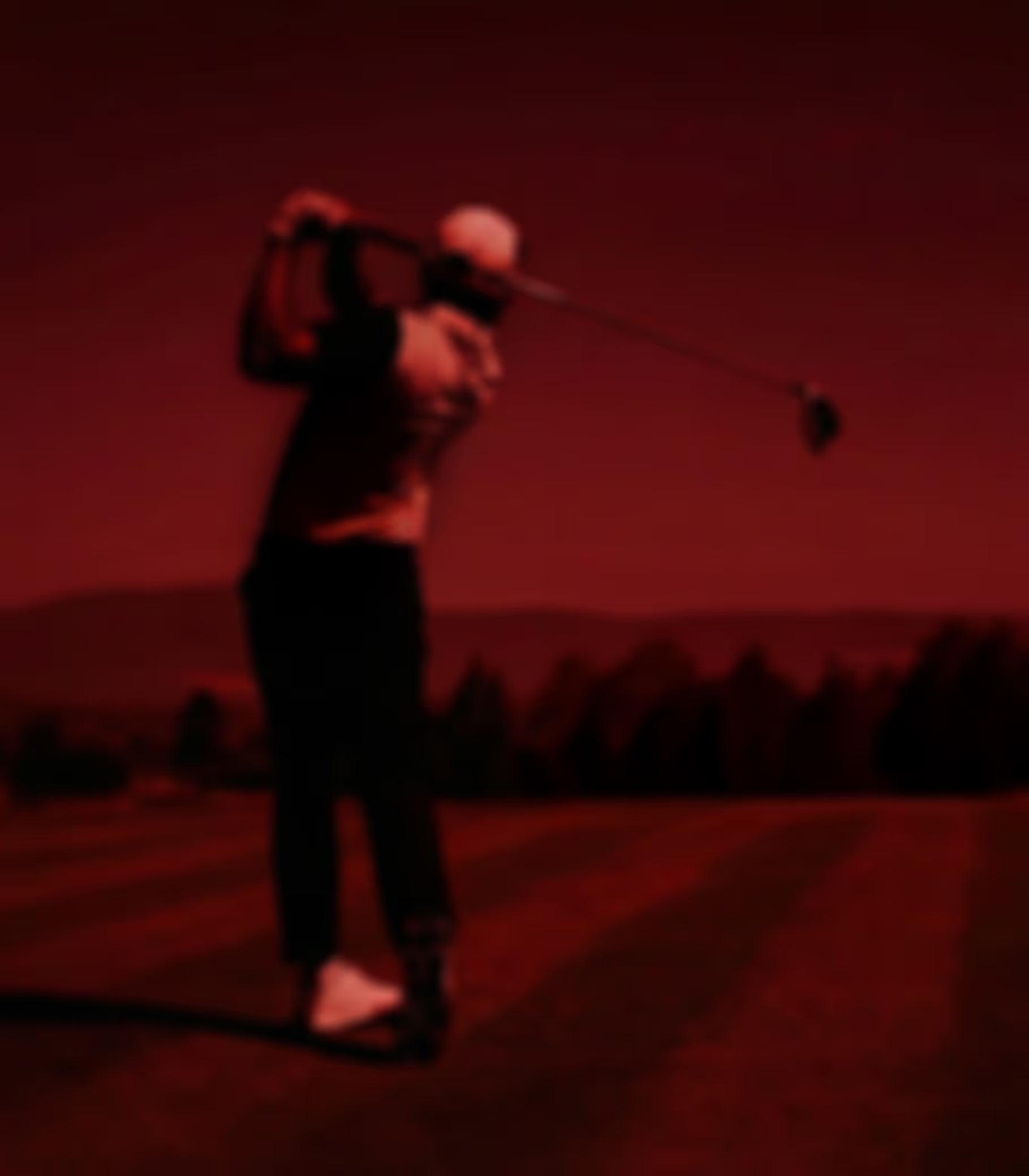 Silhouette of a golfer mid-swing against a red gradient background.